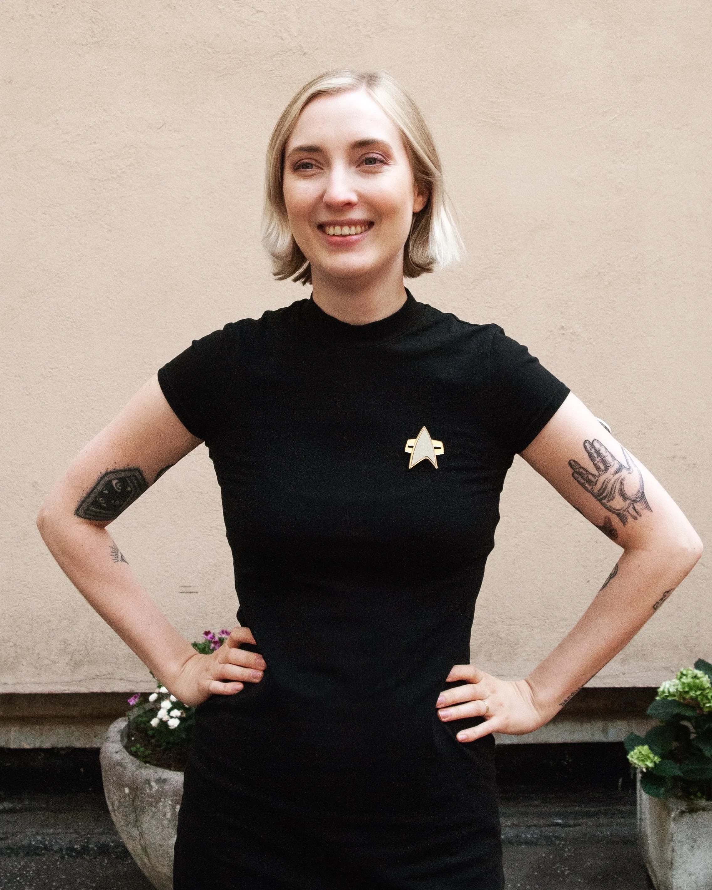 Malin, smiling, in a black top with a small star pin